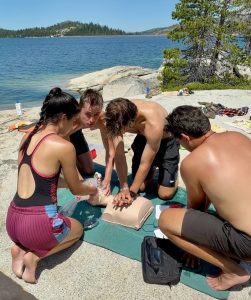 Staff training on a CPR mannequin at the beach