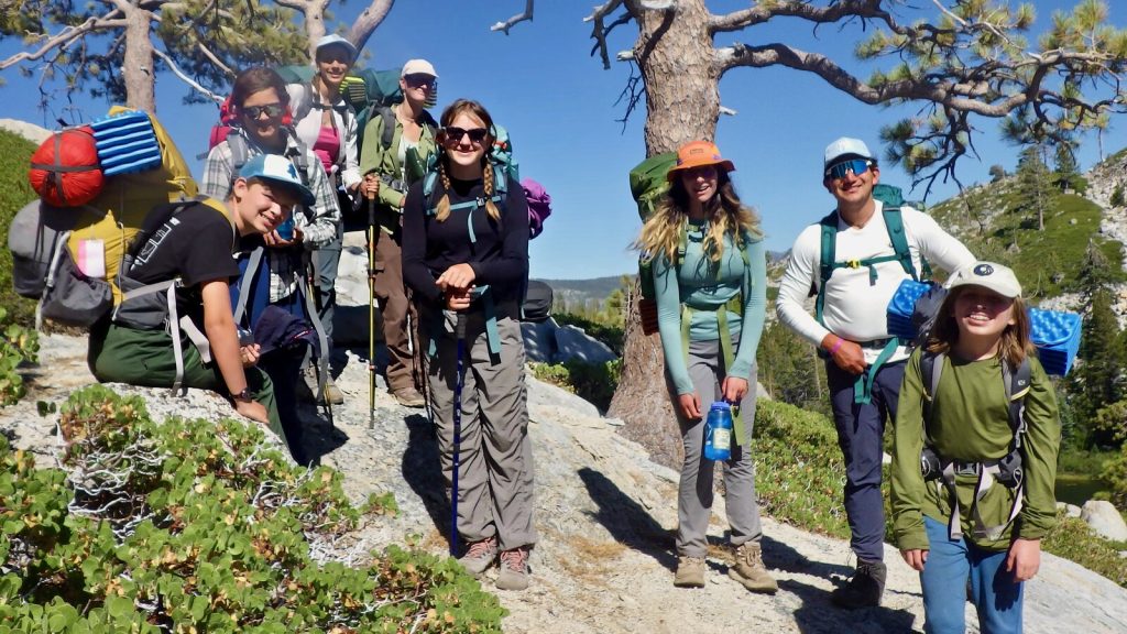 Eight backpackers climbing a ridge in Desolation Wilderness